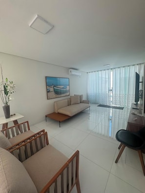 A modern living room with a sofa, chairs, a dining table, and a painting on the wall. - House in a gated community in Lençóis Maranhenses with a swimming pool and 4 suites. (Barreirinhas)