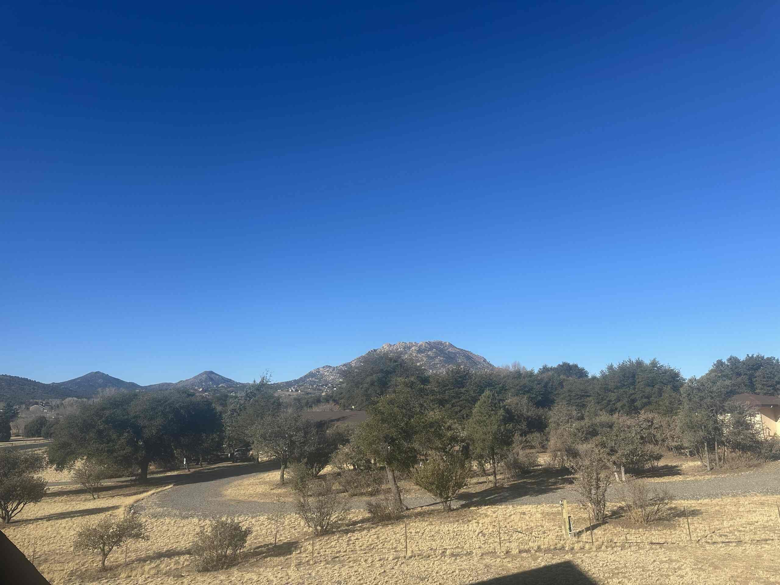 A mountainous landscape with trees and a clear sky.