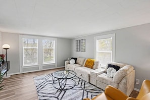 A living room with a sofa, a coffee table, and a lamp.