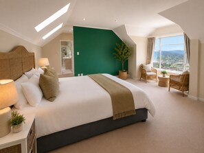 A hotel room with a large bed, a view of the city, and a green accent wall. - Sky Nova Villa False Bay Mountain & Ocean Views (Cape Town)