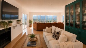 A modern living room with a sofa, a coffee table, and a fireplace. - Sky Nova Villa False Bay Mountain & Ocean Views (Cape Town)