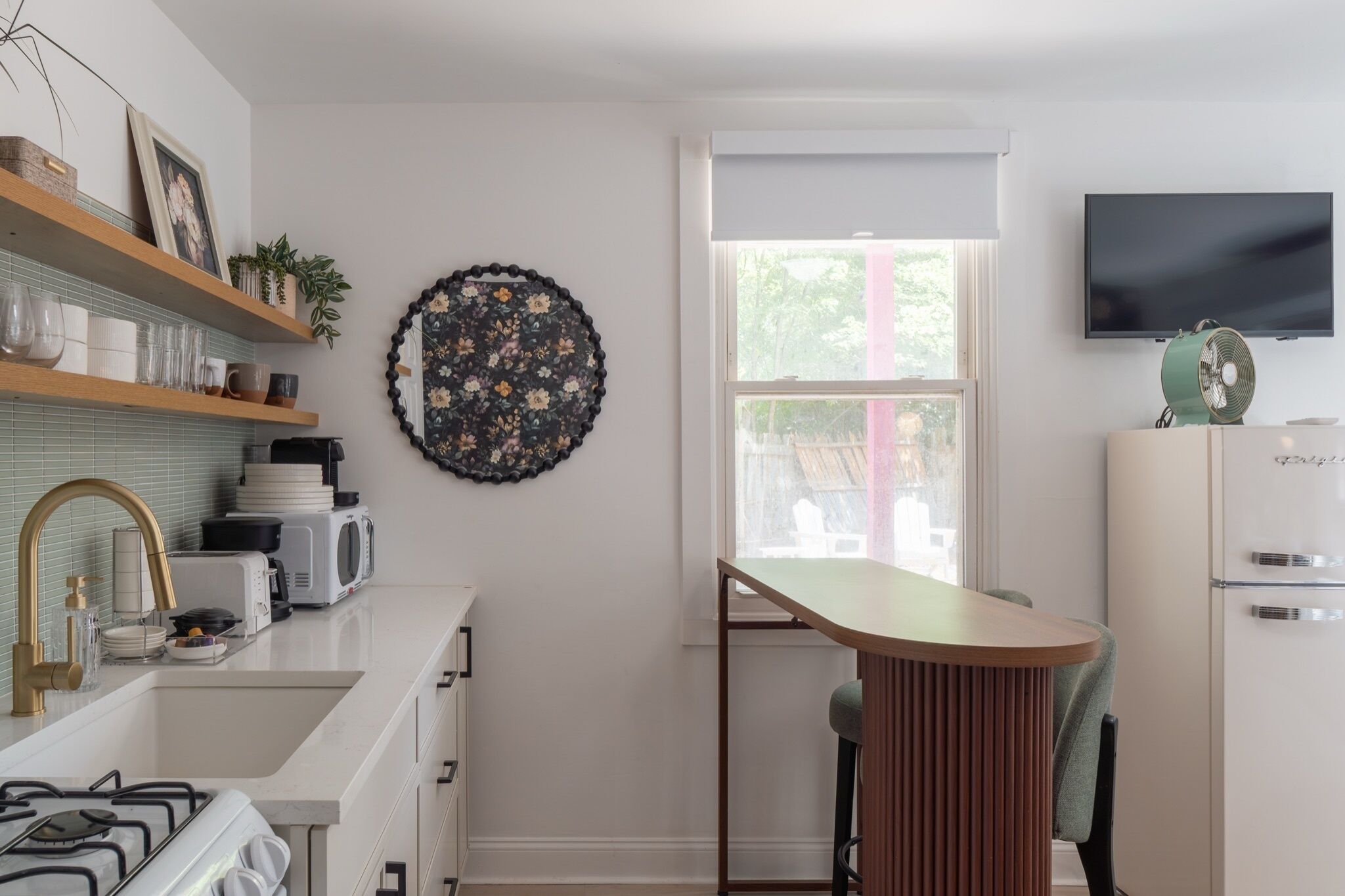 Una cucina moderna con mobili bianchi, un tavolo da pranzo in legno e un'ampia finestra.
