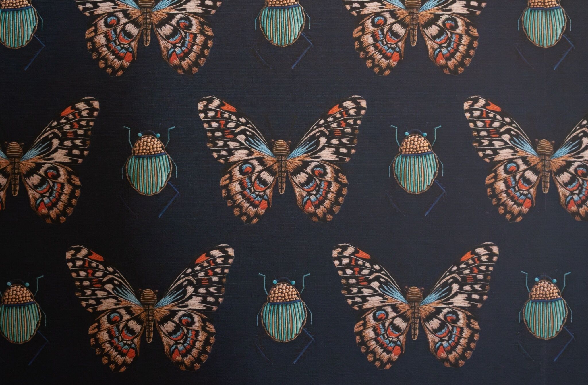A pattern of stylized butterflies and beetles on a dark background.