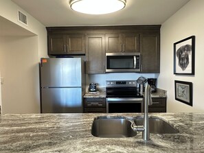 A kitchen with stainless steel appliances, granite countertops, and a double sink. - Oceanview 1BR Condo | Beach Resort | Sleeps 4 (Myrtle Beach)