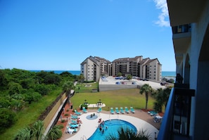 Ein Hotel mit Pool, mehreren Balkonen und Meerblick.