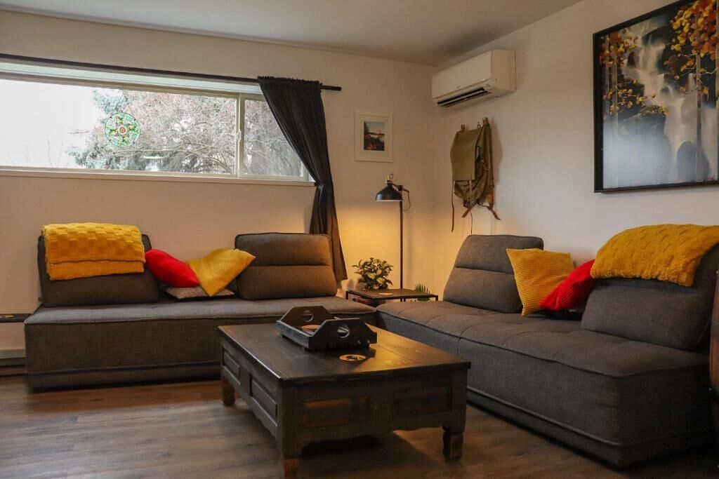 Ein Wohnzimmer mit einer Sofagarnitur, einem Couchtisch und einem Bild an der Wand.