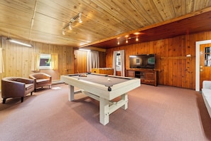A pool table in a room with wooden walls and a television. - Spacious 3BR Home with Pool Table & Patio Near Lake Erie (Westfield)