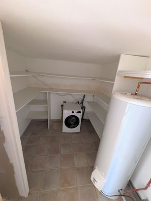 A laundry room with a washing machine, a water heater, and a tiled floor. - Horizon Pond Villa with Pool and Panoramic View (Rognac)