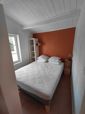 A bedroom with a bed, a wardrobe, a nightstand, and a window. - Our house, just 4 minutes from the beaches (La Guérinière)