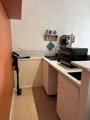 A compact kitchen with a built-in oven, a coffee maker, and a microwave. - Our house, just 4 minutes from the beaches (La Guérinière)