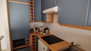 A compact kitchenette with a sink, stove, and coffee maker. - Incredible ocean view, pool, HVAC, Wi-Fi, sleeps 4 (Vallauris)