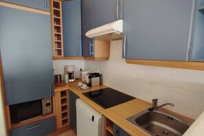 A compact kitchenette with a microwave, coffee maker, and a small refrigerator.