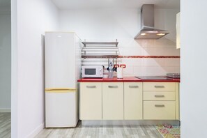 A modern kitchen with a white refrigerator, a microwave, and a red countertop. - Home2Book Bright Stay in Los Abrigos (Los Abrigos)