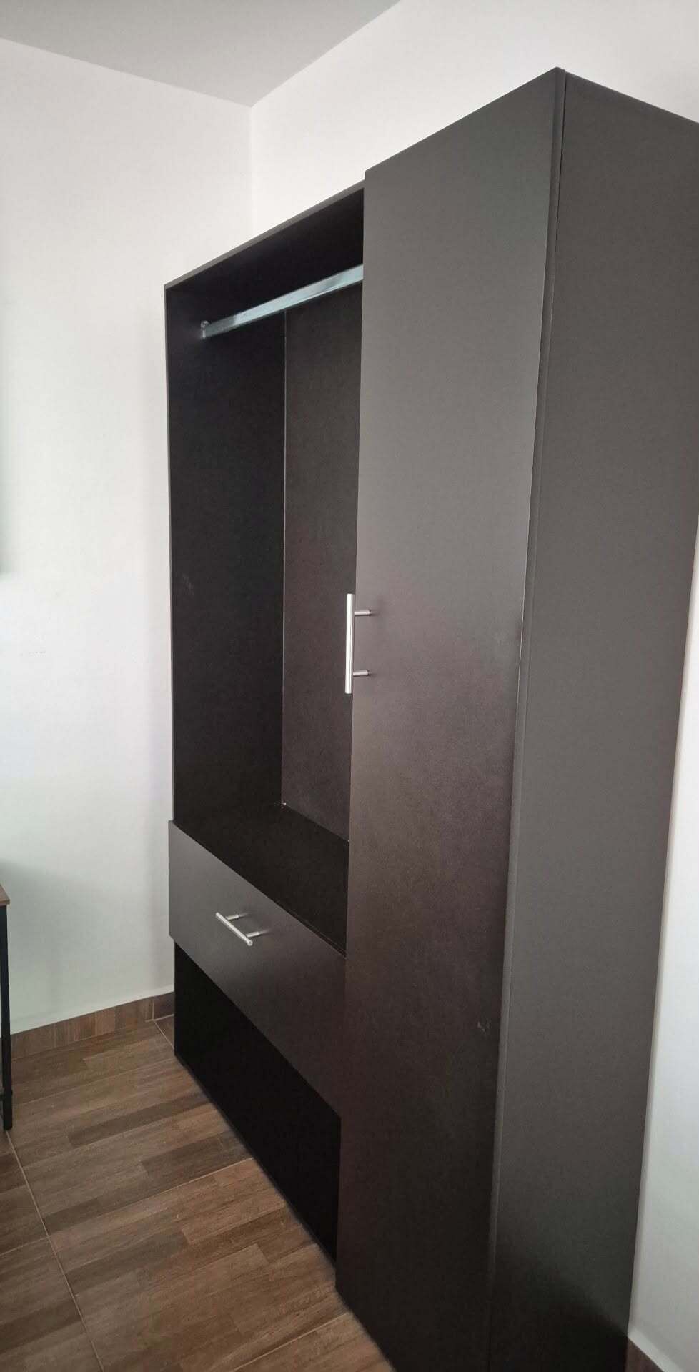 Un armario con puerta corredera y estante incorporado.