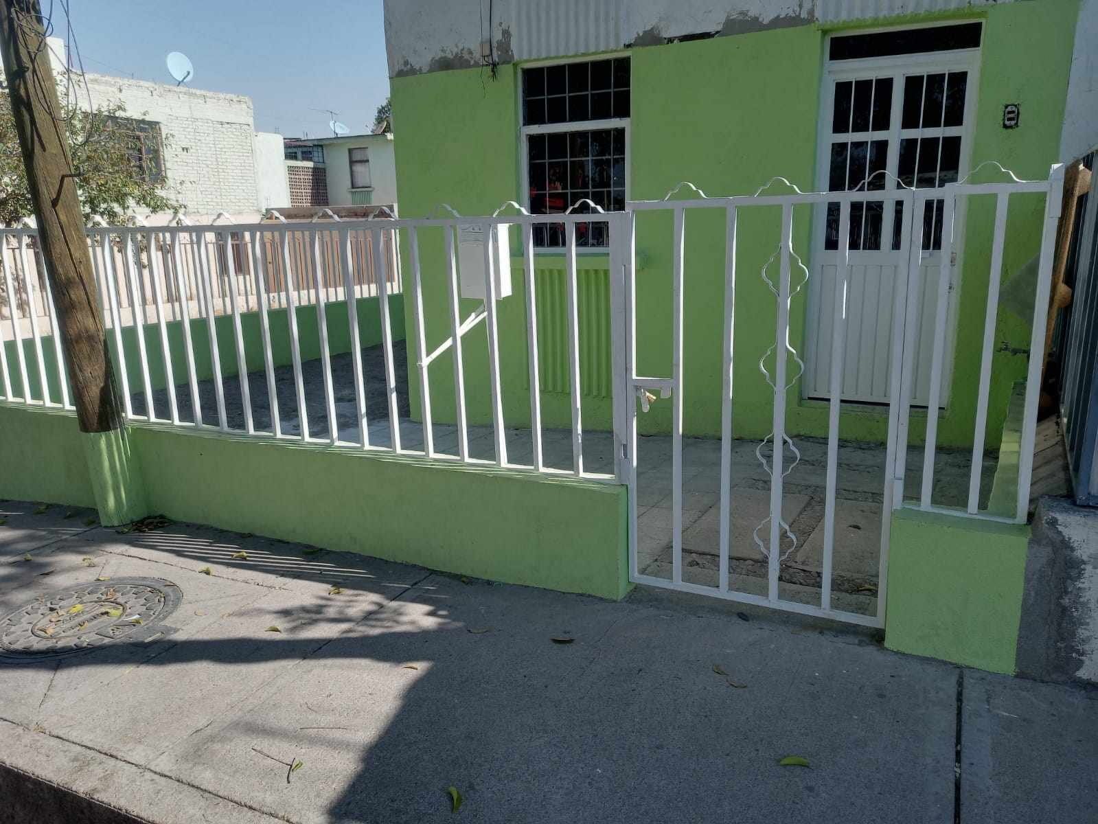A gated area with a green wall and a white gate.