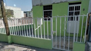 A gated area with a green wall and a white gate.