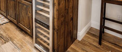 Una cocina con armarios de madera, un electrodoméstico de acero inoxidable y un tapete estampado.