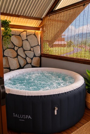 A hot tub with a stone wall and a view of the outdoors. - Ananda | Cabin with a mountain view and a hot tub (Alcalde)