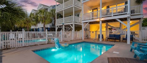 A multi-story building with a swimming pool and outdoor seating.