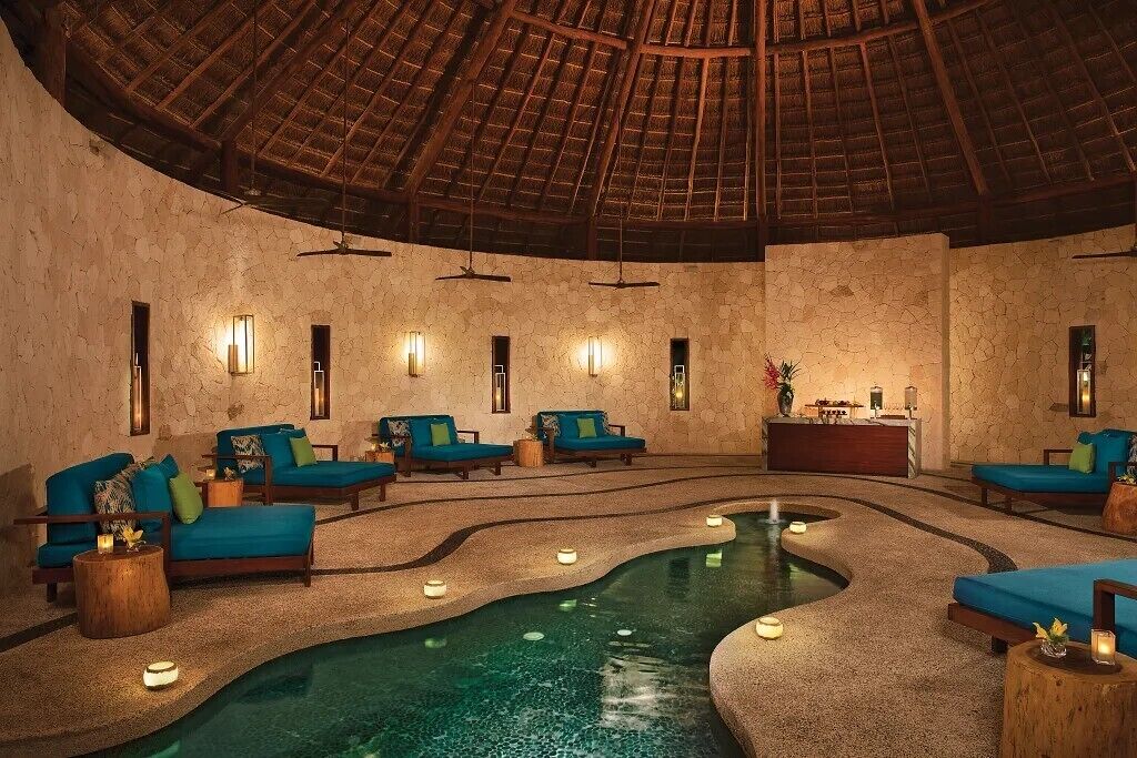 A spa area with a pool, seating, and a reception desk.