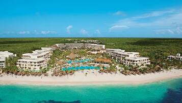 A resort with a central pool, beachfront, and multiple buildings.