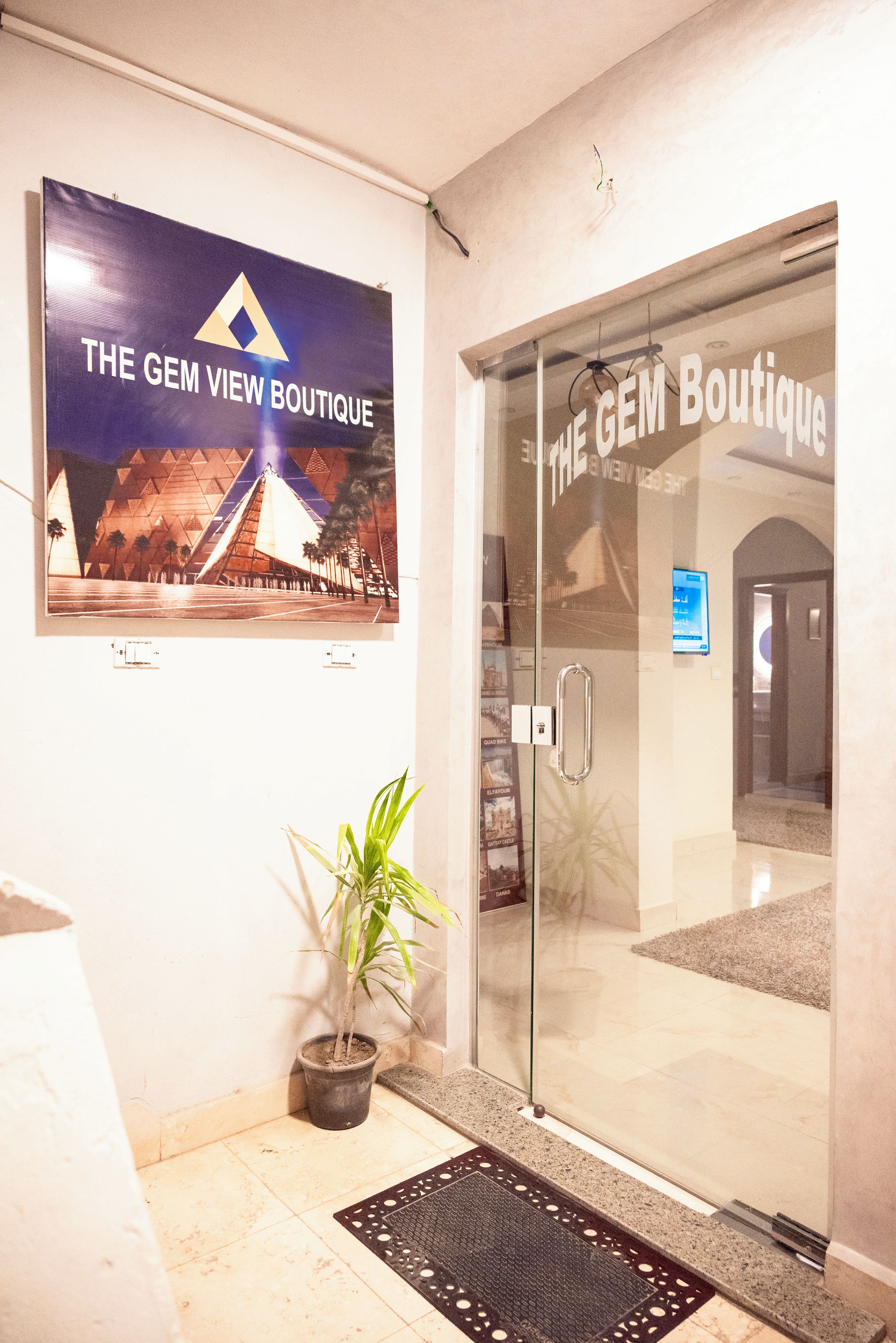 A glass door entrance to a boutique with a sign above it.