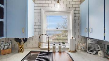 A kitchen with a window, a sink, and cabinets.