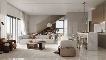 A modern living room with a sofa, coffee table, and a dining area with chairs.