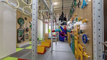 Ein Fitnessstudio mit verschiedenen Trainingsgeräten, darunter Ringen, einem Sandsack und einer Kletterwand.