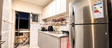 A modern kitchen with stainless steel appliances, including a refrigerator and a stove.