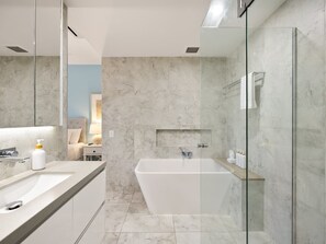 A modern bathroom with a large bathtub, a glass shower enclosure, and a vanity with a mirror. - Deluxe Three-Bedroom Apartment Apt 8 (Mooloolaba, Sunshine Coast)
