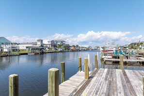 A marina with docked boats and a wooden pier. - Canalfront dock and screened porch (Surf City)