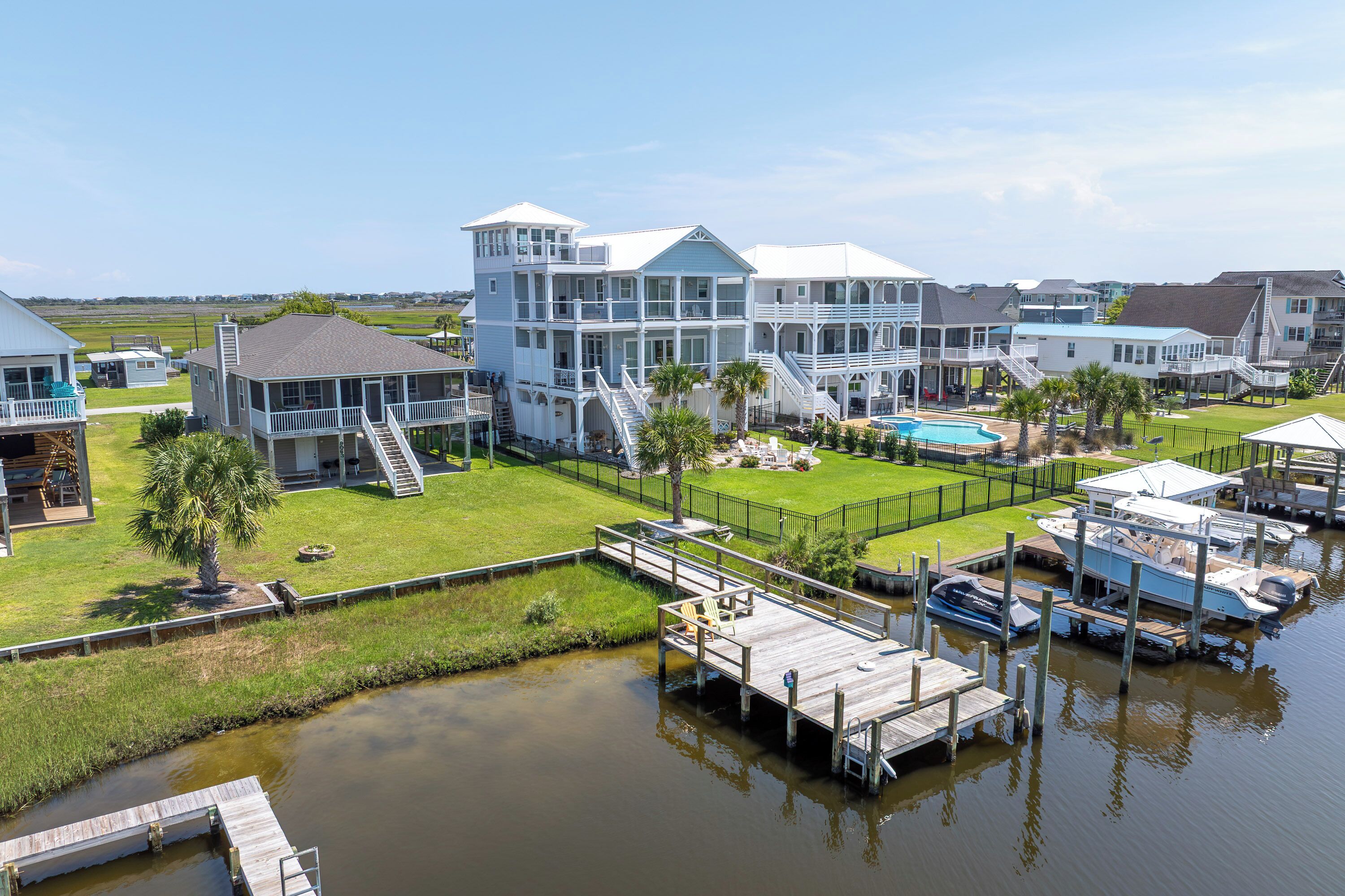 A waterfront property with multiple buildings, a dock, and a swimming pool.