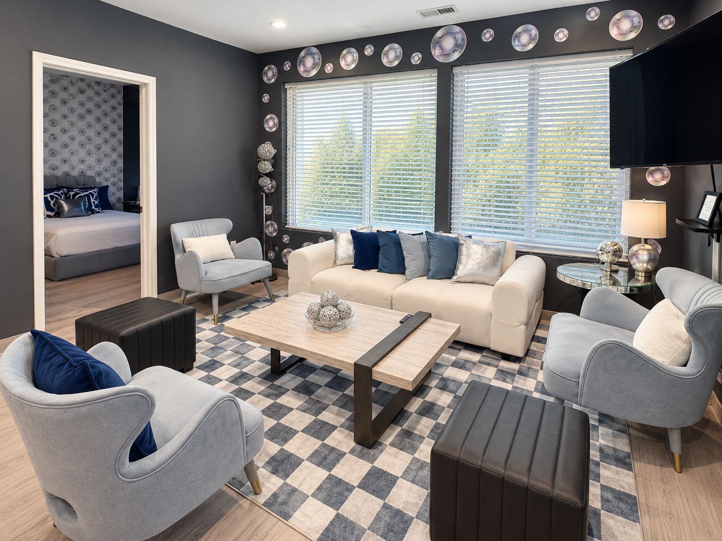 A modern living room with a sofa, chairs, a coffee table, and a television.