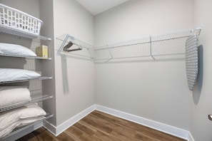 A storage closet with shelves and hanging space for clothes. - Cozy 3-bedroom cottage in delightful Pensacola with AC. 10 Mins from the beach. (Pensacola)