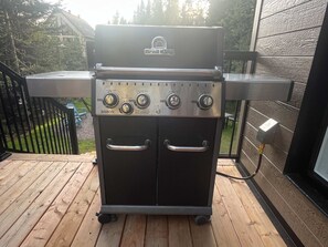 Un barbecue portable doté de quatre brûleurs, d’un écran numérique et d’une poignée sur chaque porte.