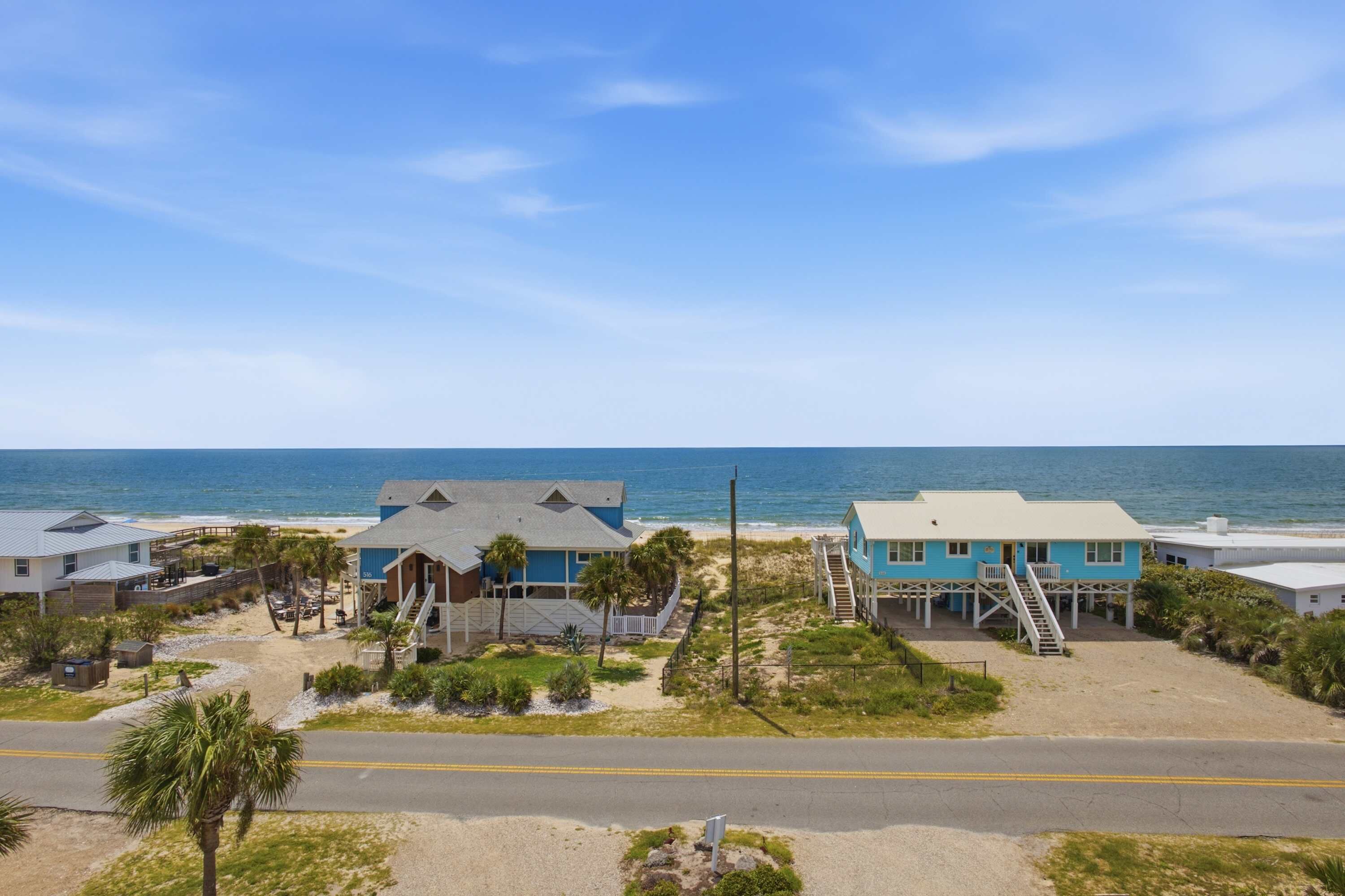 A coastal property with multiple buildings, a beach, and a road.