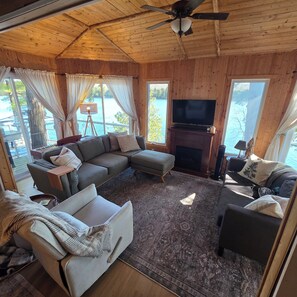 A cozy living room with a sectional sofa, a fireplace, and a television. - Lil' Bears' Lair (Arnstein)