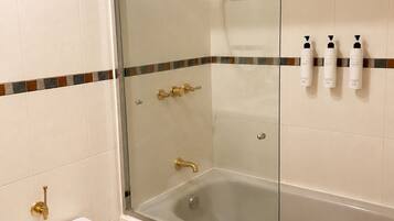Un baño con bañera, inodoro y zona de ducha.