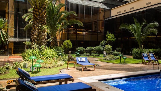 Un área de piscina interior con sillones de descanso y un pequeño jardín.