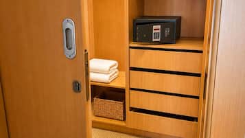 A wooden closet with shelves, a hanging rack, and a microwave.