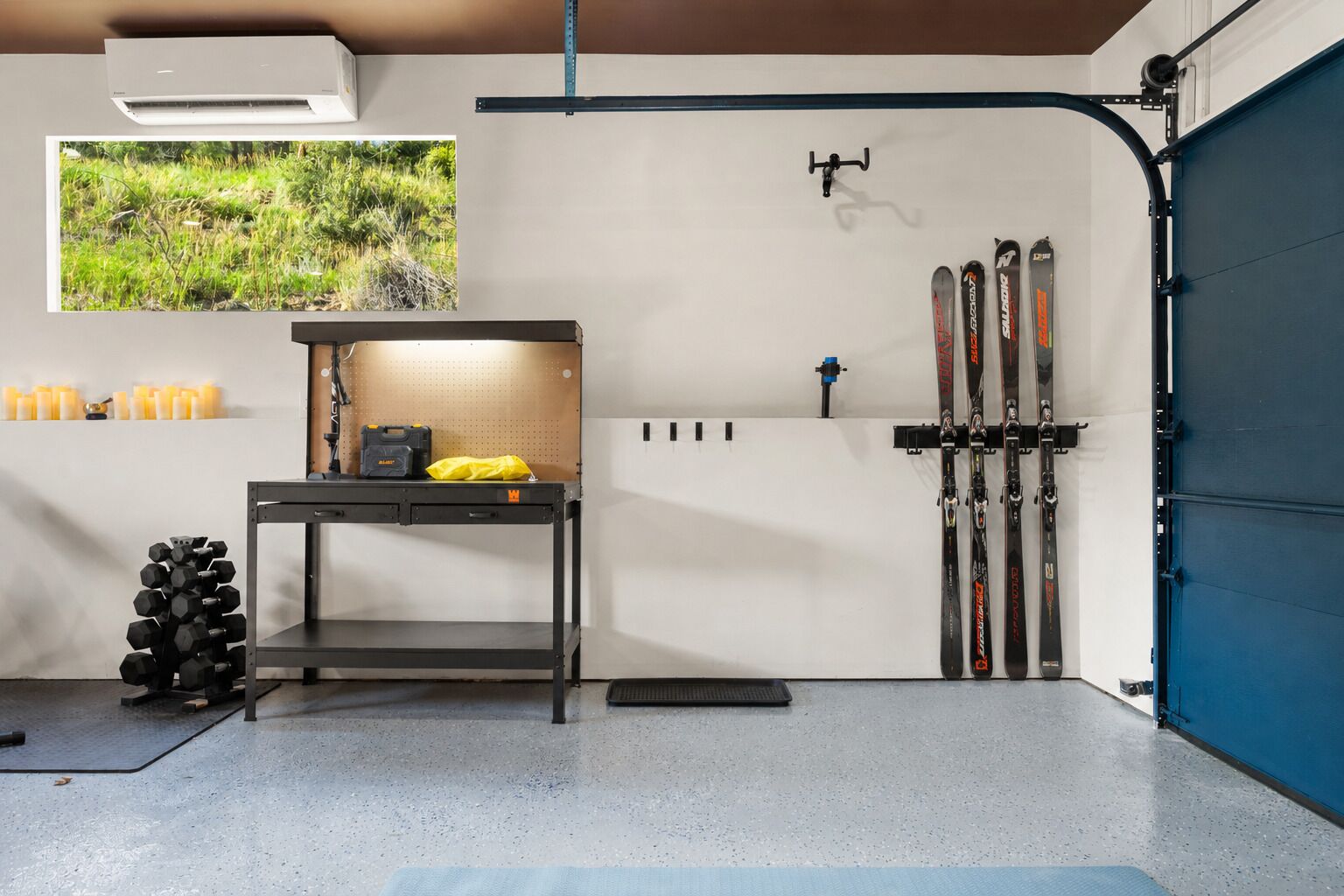 Een skiopslagruimte met ski's, een tafel met materiaal en een wandrek.
