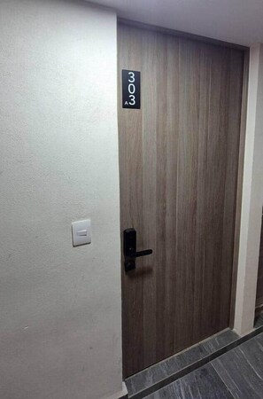 Une porte avec une plaque indiquant le numéro de la chambre : 303.