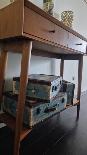 Ein Holztisch mit Schublade und Ablagefläche für antike Koffer.