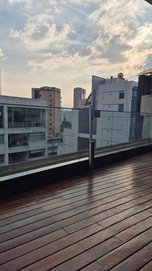 Eine Holterrasse mit Blick auf moderne Gebäude und einen bewölkten Himmel.