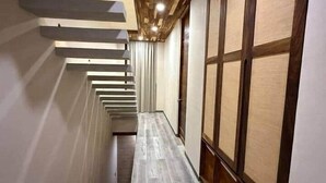 A narrow hallway with a wooden ceiling and a long, narrow room with tatami mats. - Deisy TownHouse Oaxaca (San Pedro Mixtepec)