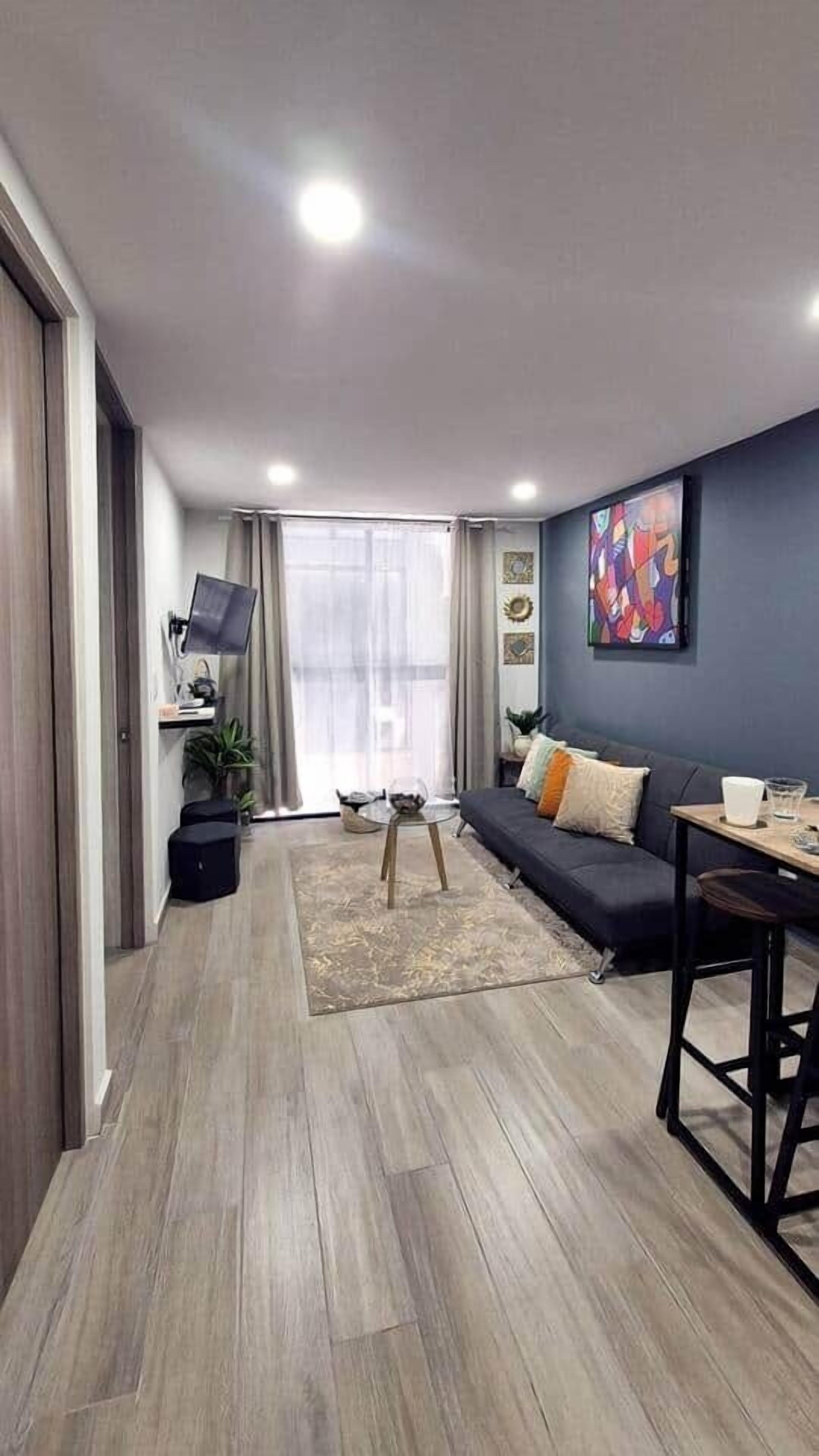 A modern living room with a sofa, a coffee table, and a TV.