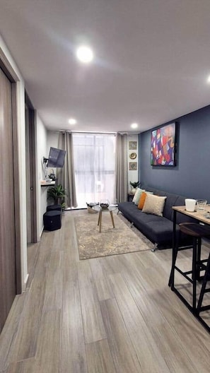 Ein modernes Wohnzimmer mit einer Couch, einem Couchtisch und einem Fernseher.