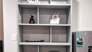 A grey shelving unit with decorative items and a refrigerator. - 103 Insurgentes Nayeli (Mexico City)