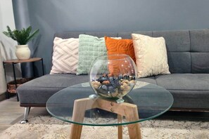 A glass coffee table with a bowl of pebbles on a wooden stand. - 103 Insurgentes Nayeli (Mexico City)